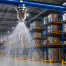 Industrial sprinkler in action above racks
